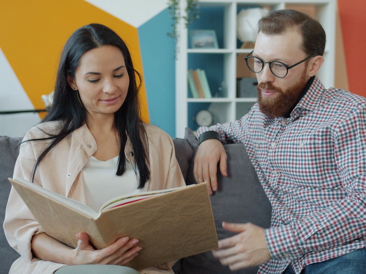 Two people sharing a warm, candid moment reading together at home